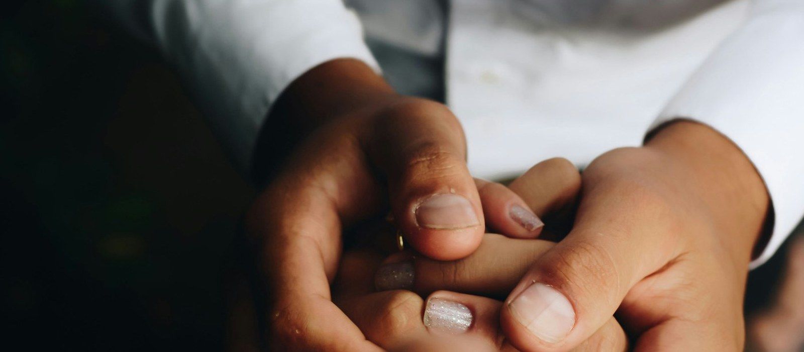 Two people's hands, held.